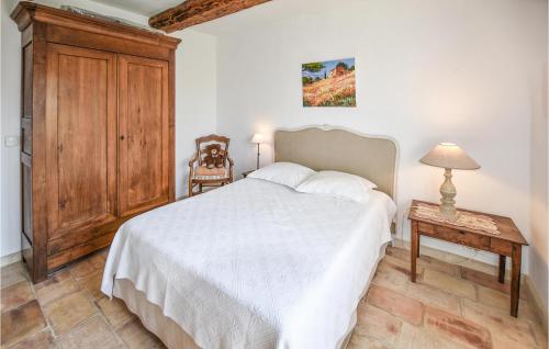 een slaapkamer met een wit bed en een houten kast bij Lovely Home In Rochefort-du-gard With Private Swimming Pool, Can Be Inside Or Outside in Rochefort-du-Gard