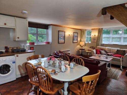 a kitchen and living room with a table and chairs at The Old School Caeathro, Snowdon, Eryri and Yr Wydffa Cottages in Caernarfon