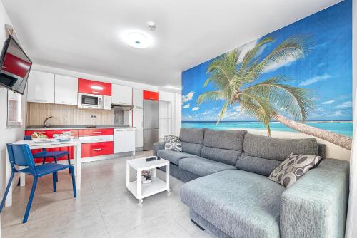 a living room with a couch and a palm tree mural at Sol Mogan Suites - Adults Only in Puerto de Mogán