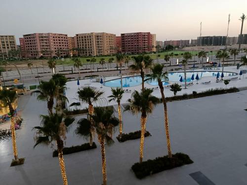 uma vista aérea de uma piscina com palmeiras em Chalet in the middle of north coast em El Alamein