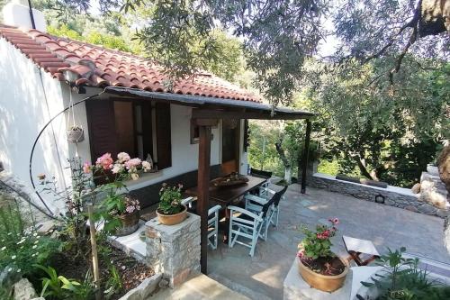 a patio with a table and chairs and a house at kalivi in Skiathos Town