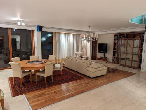 a living room with a table and a couch at Luxury Breathtaking Seafront Penthouse Duplex in Rishon LeẔiyyon
