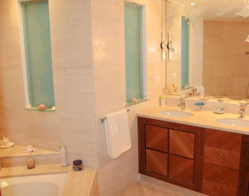 bagno con vasca, lavandino e specchio di Luxury Breathtaking Seafront Penthouse Duplex a Rishon LeẔiyyon