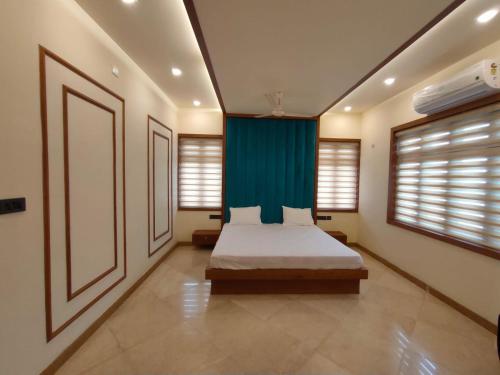 a bedroom with a bed and a blue curtain at Nandhanam Holidays in Kannur