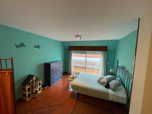ニグランにあるPrimera Línea PLAYA PATOS Nigránの青い壁のベッドルーム1室、ベッド1台、窓が備わります。