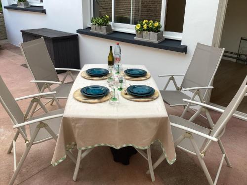 a table with blue plates and a bottle of wine at LE 16 CHAMBRES D'HÔTE in Friville-Escarbotin