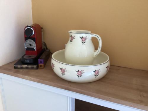 a cup and a bowl on top of a cabinet at LE 16 CHAMBRES D'HÔTE in Friville-Escarbotin
