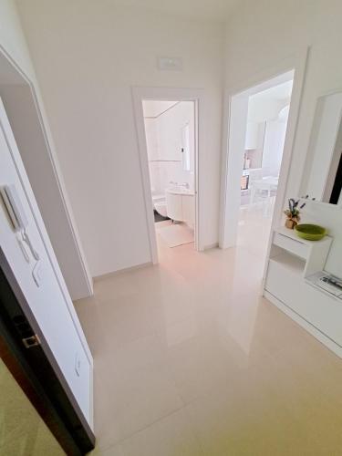 a white room with a hallway with a mirror at Casa Ely in Sottomarina
