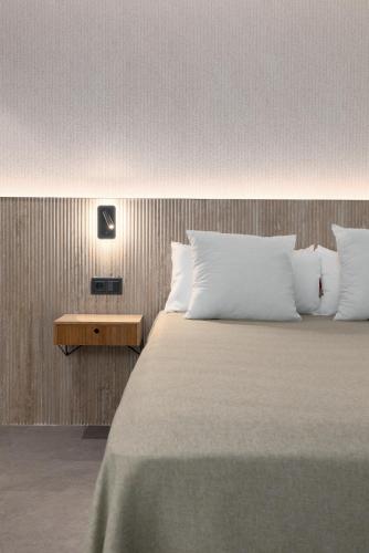 a bedroom with a large bed with white pillows at Calatrava by Alma Suites in Valencia