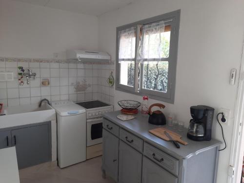 une cuisine avec un évier et une cuisinière four supérieur dans l'établissement Maison tout près du port et des restaurants de Saint Aygulf, à Saint-Aygulf