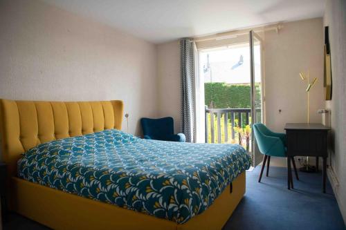Schlafzimmer mit einem Bett, einem Fenster und einem Schreibtisch in der Unterkunft Appartement avec terrasse vue mer Trouville sur mer in Trouville-sur-Mer