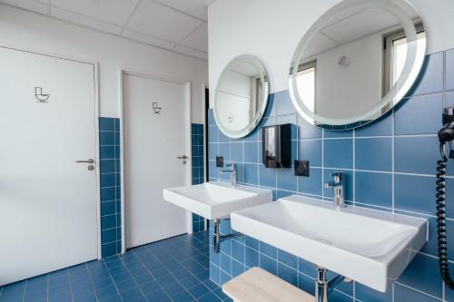 La salle de bains est pourvue de 2 lavabos et d'un miroir. dans l'établissement JOST Auberge de Jeunesse Bordeaux Gare Saint Jean, à Bordeaux