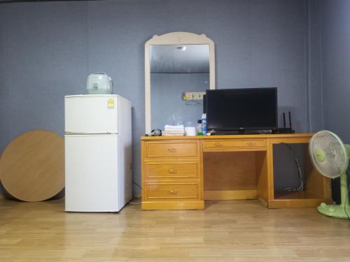 een kamer met een koelkast en een bureau met een spiegel bij Songwol Park in Sokcho