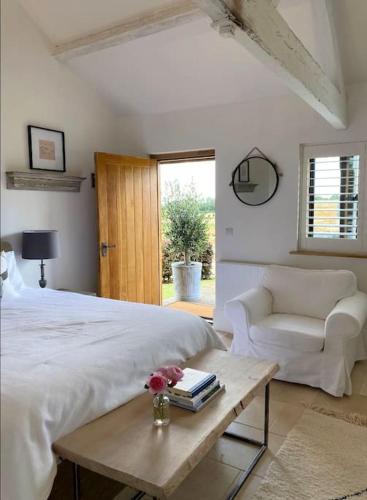 a bedroom with a bed and a couch and a table at Luxury & comfort in the Cotswolds in Banbury