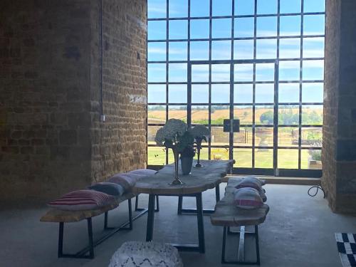 Habitación con mesa con almohadas y ventana grande. en Stunning 'Room with a view', en Banbury