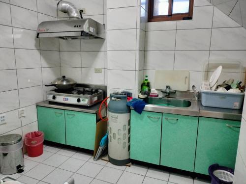 a small kitchen with a sink and a stove at Happy Inn in Juguang