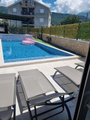 a swimming pool with two chairs and a frisbee at Villa with Pool & Garden apartment 1 Ognjen in Tivat