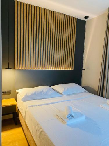 a bedroom with a large white bed with a window at Beach Hotel Božikovina in Podstrana