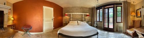 Le Buisson de CadouinにあるLe Manoir de Belleriveのオレンジ色の壁のベッドルーム1室(ベッド1台付)