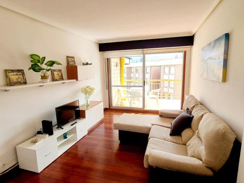 a living room with a couch and a television at Apartamento Pilartxo Zarautz in Zarautz
