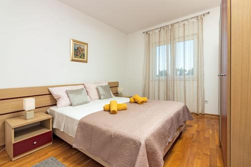 a bedroom with a bed with two stuffed animals on it at Apartment Mandalina House in Stari Grad