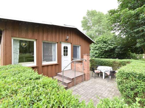 a small house with a staircase and a patio at Quaint Bungalow near Insel Poel with Garden in Insel Poel