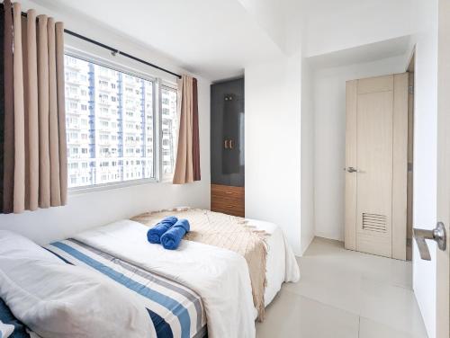 a bedroom with two beds and a large window at Balikbayan 2BR Condo QC SM North EDSA Parking in Manila
