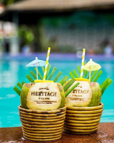 two baskets with umbrellas in them next to a pool at Heritage Village Resort & Spa Goa in Cansaulim
