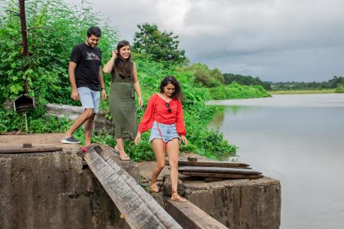 a group of three people standing on a bridge over a river at Heritage Village Resort & Spa Goa in Cansaulim