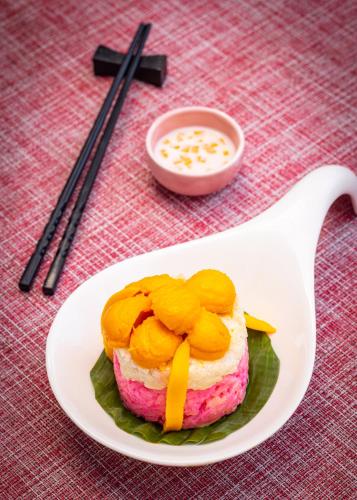 a cake with fruit on a plate on a table at Heritage Village Resort & Spa Goa in Cansaulim