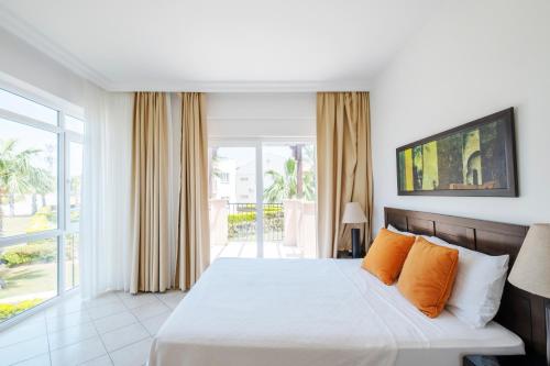 アクブクにあるApollonium Spa & Beach Resortのベッドルーム1室(オレンジ色の枕が付いたベッド1台付)