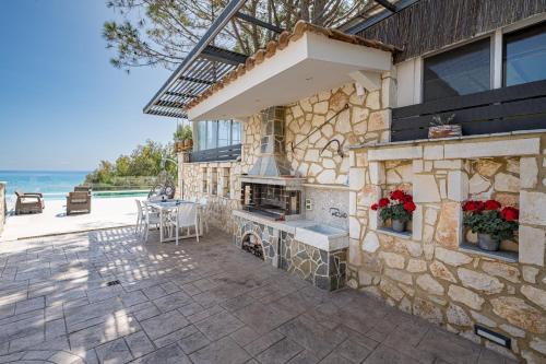 a stone house with a fireplace and a patio at Addimare Sea View Villa, and Events Venue in Alykes