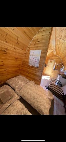 a bedroom with a bed in a room with wooden walls at Hobití chatka Lipno in Černá v Pošumaví