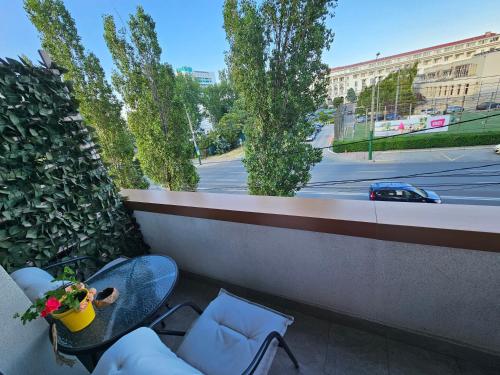 d'un balcon avec une table et des chaises offrant une vue sur la rue. dans l'établissement Iaki Apartment Mamaia, à Mamaia