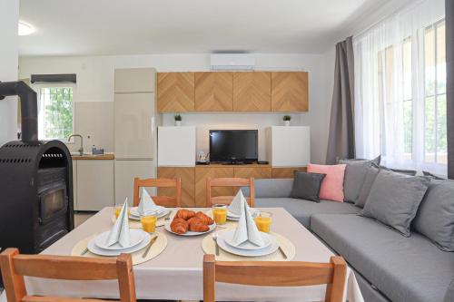 uma sala de estar com uma mesa e um sofá em Golden Apartman Balatonlelle em Balatonlelle