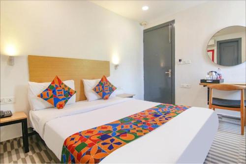 Cette chambre comprend un grand lit blanc avec des oreillers colorés. dans l'établissement Hotel The Rasa Near Welcome Metro Station, à New Delhi