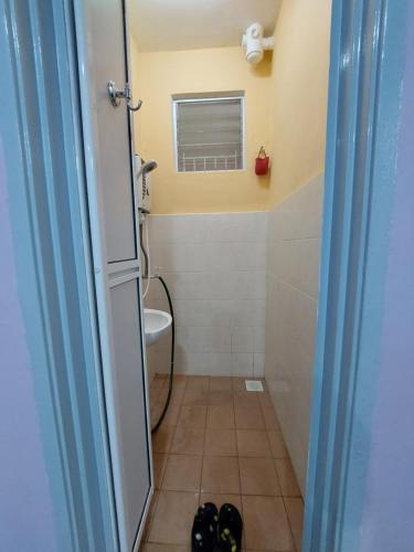 uma casa de banho com um WC, uma janela e uma porta em Homestay Warisan Violet em Malaca