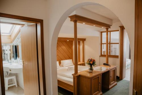 a bathroom with a bed and a sink and a mirror at Weßner Hof Landhotel & Restaurant in Marquartstein