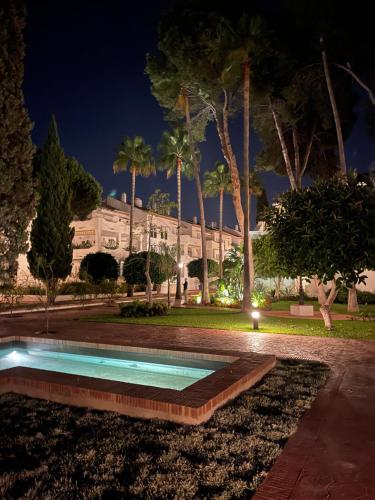 エステポナにあるSeaside condo with pool, Marbellaの夜の公園内のスイミングプール