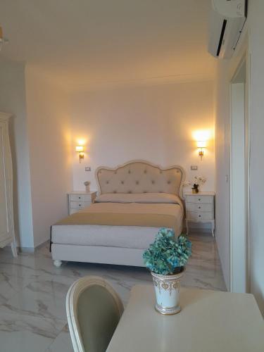 a bedroom with a bed and a table with a potted plant at La Vigna del Vento in Casola di Napoli