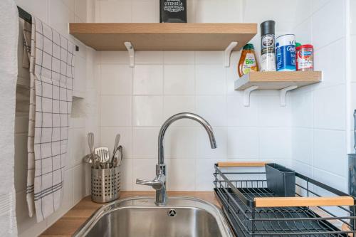 - une cuisine avec un évier et une étagère dans l'établissement Logement de standing à 18min de Paris La Défense, à Colombes