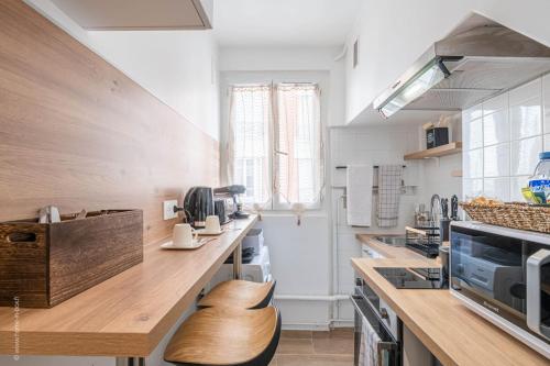 - une cuisine avec un comptoir en bois et un comptoir dans l'établissement Logement de standing à 18min de Paris La Défense, à Colombes