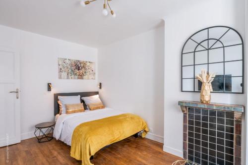 a bedroom with a bed and a fireplace at Logement de standing à 18min de Paris La Défense in Colombes