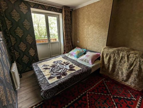 - un petit lit dans une chambre avec fenêtre dans l'établissement Baitur, à Naryn