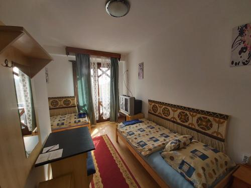 a small room with two beds and a kitchen at Valcsics Villa Panzió in Pécs