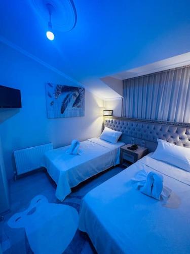 two beds in a room with blue lights at Ak Home Dublex - apartment in Çanakkale