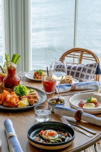 a wooden table with plates of food on it at The Godolphin Hotel in Marazion