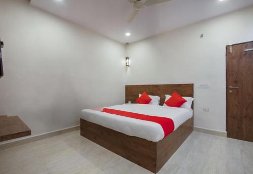 um quarto com uma cama grande e almofadas vermelhas em Hotel Holiday Rani Gunj Opp Punjab national bank em Secunderābād