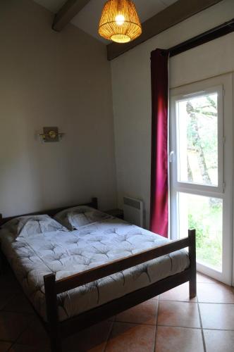 a bedroom with a bed next to a window at Black Mountain Village in Cuxac-Cabardès