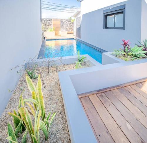 a swimming pool in a house with a wooden deck at Villa standing 50 in Ravine des Cabris